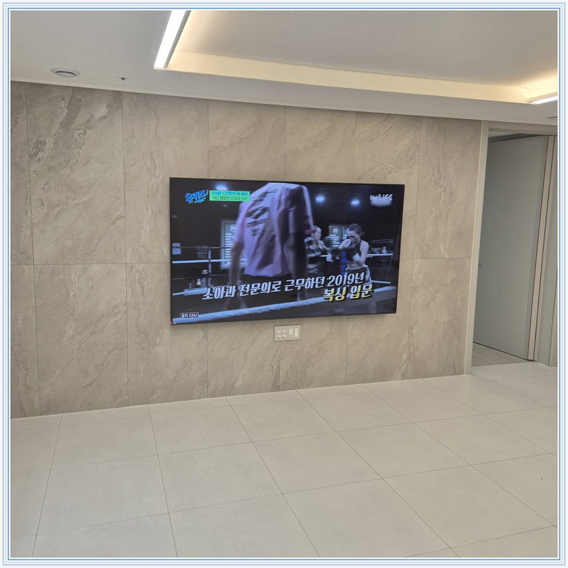 우드 톤 가구와 이어지는 벽면 화면, TV 설치 참고 사진