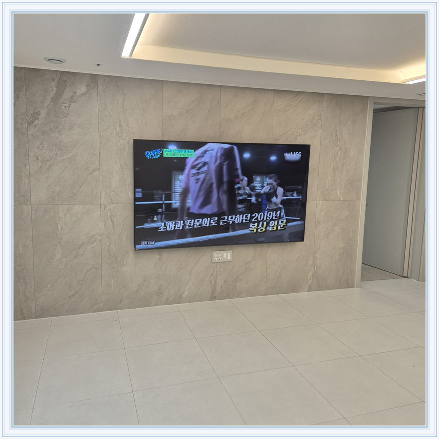우드 톤 가구와 이어지는 벽면 화면, TV 설치 참고 사진